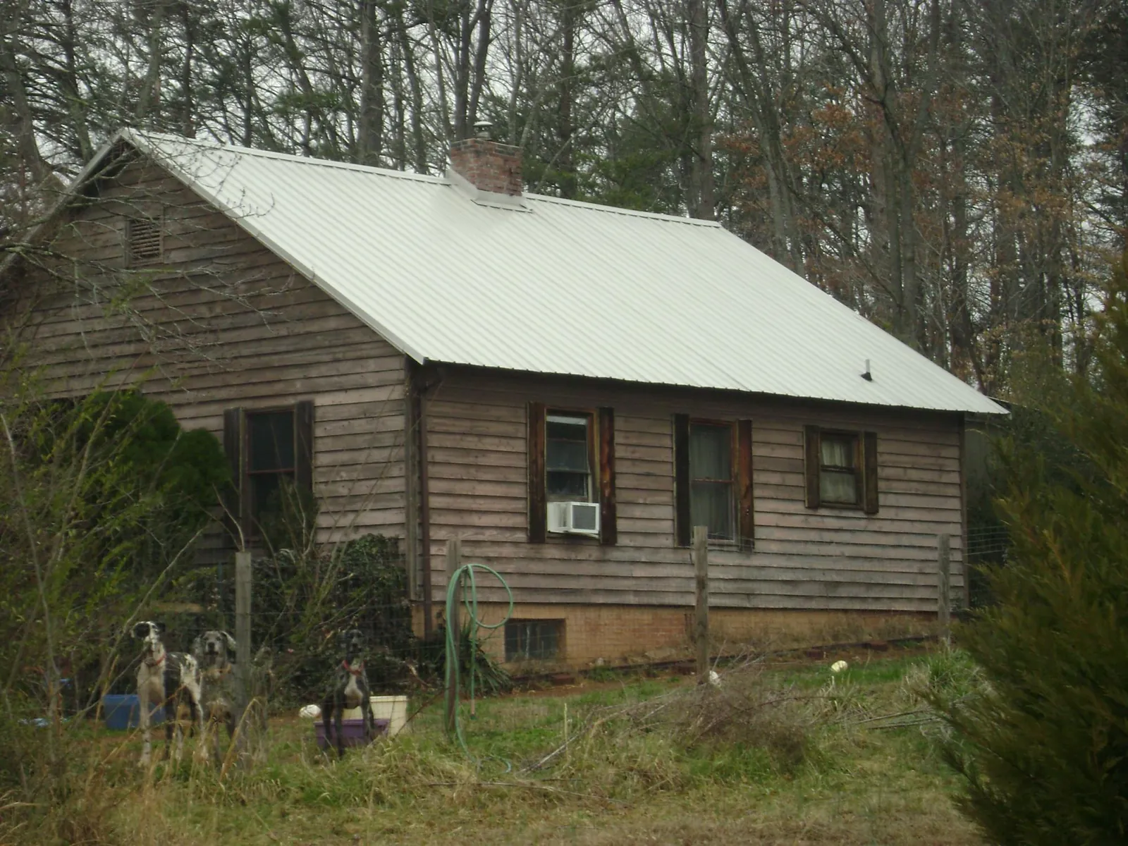 White metal roof on an old wood sided farmhouse, from a Metal Roof Installation job in Cassville